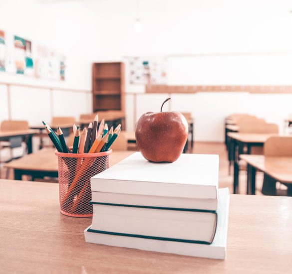 Back to School Concept. Accessories and books, blurred classroom in the background